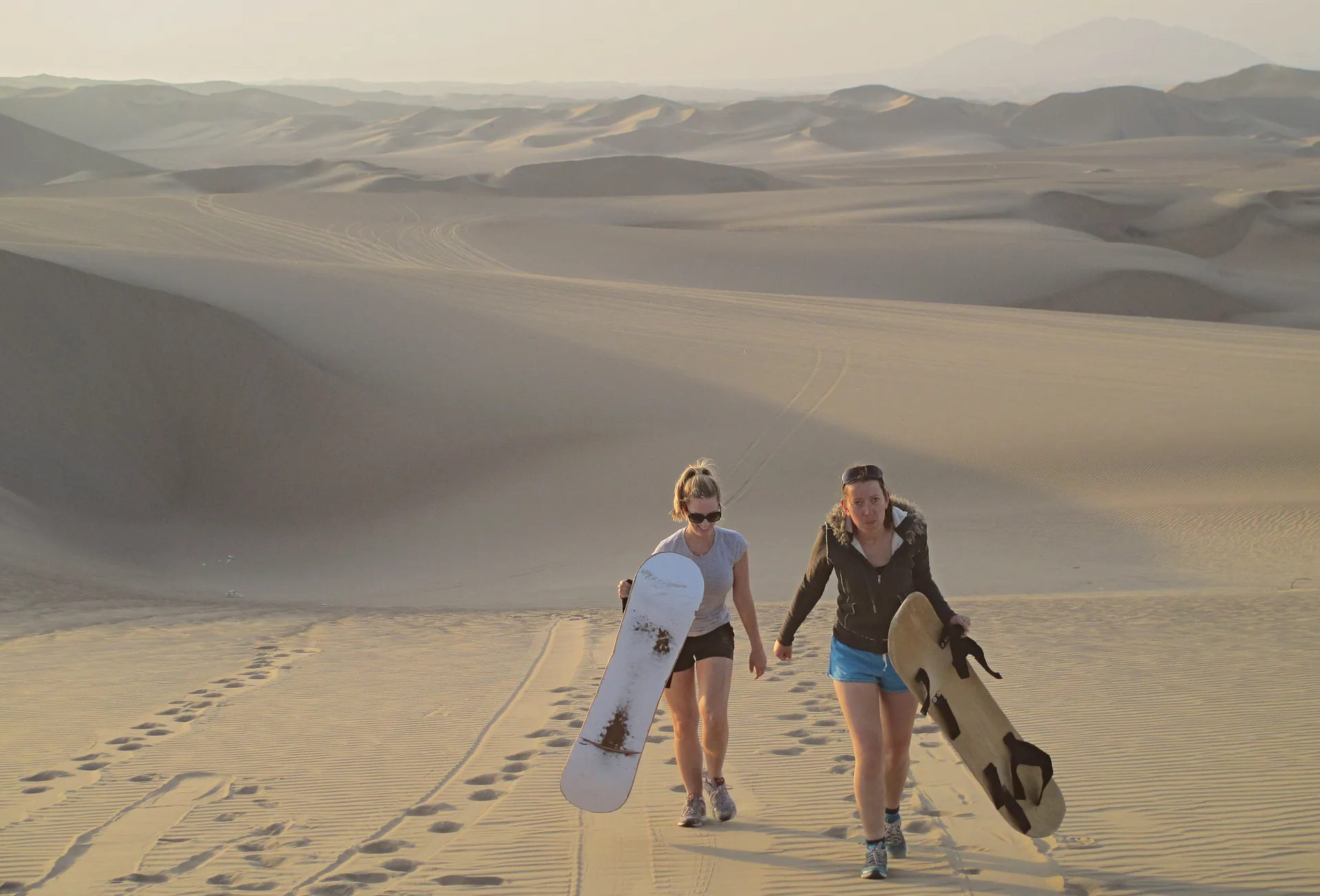 Sandboarding down a desert dune
